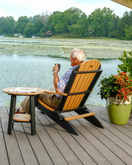 Enjoying a sip of coffee in an Adirondack folding chair, on a dock with a LuxCraft Deluxe End Table