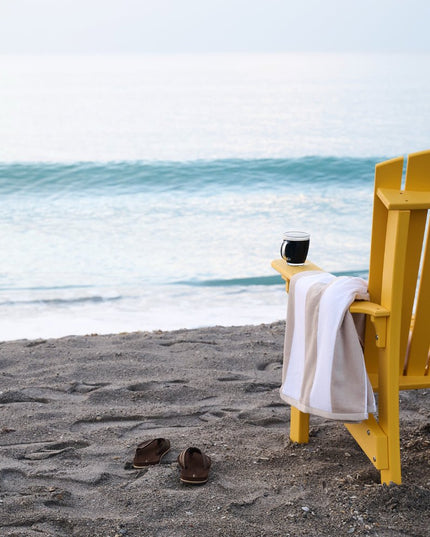 Royal Adirondack chair, yellow, looking over the ocean.